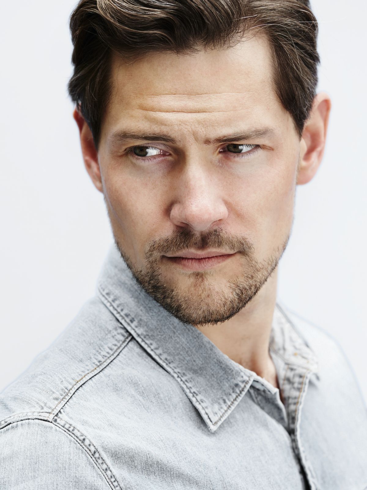 man with stylish hair standing against a white background