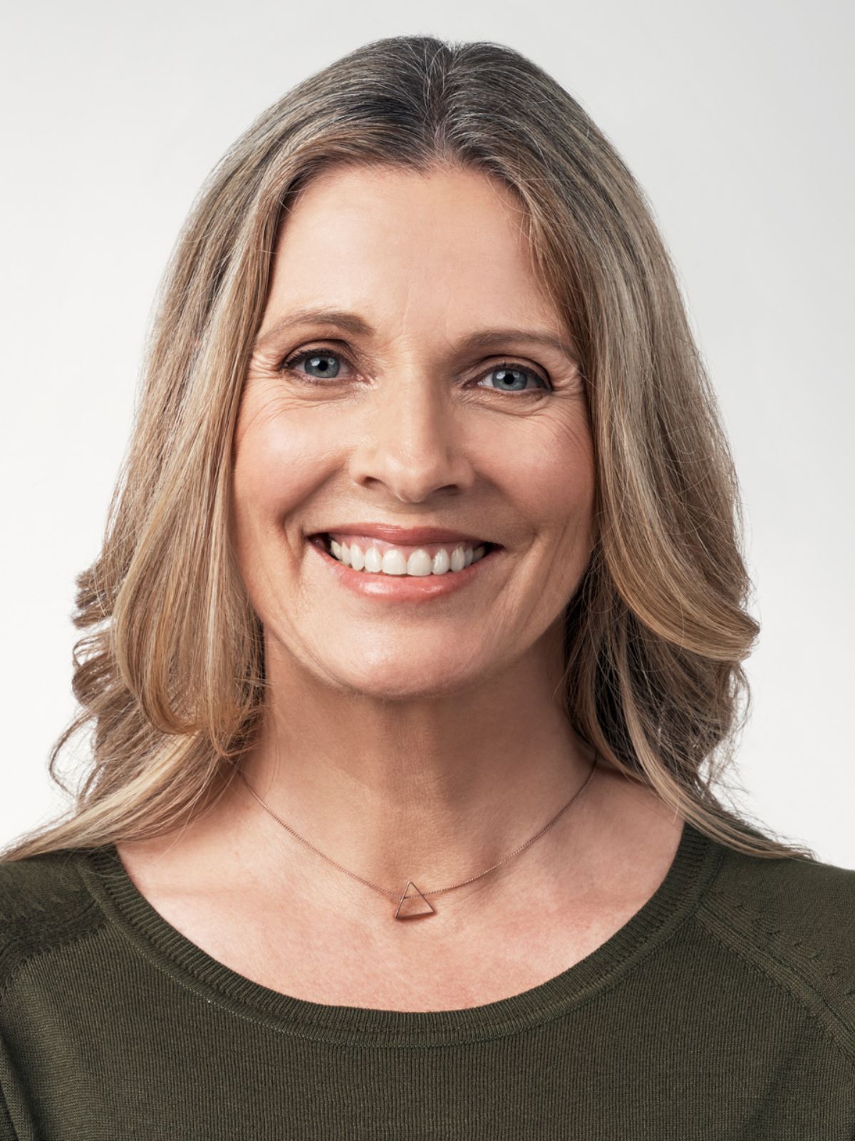 mature woman with blond hair with blue eyes against a white background