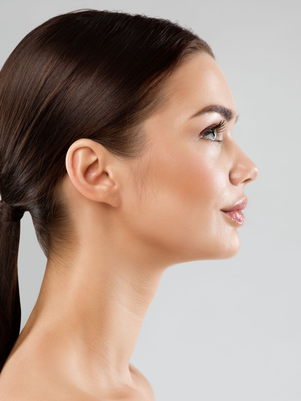 woman with her hair pulled back in profile view highlighting her chin and neck